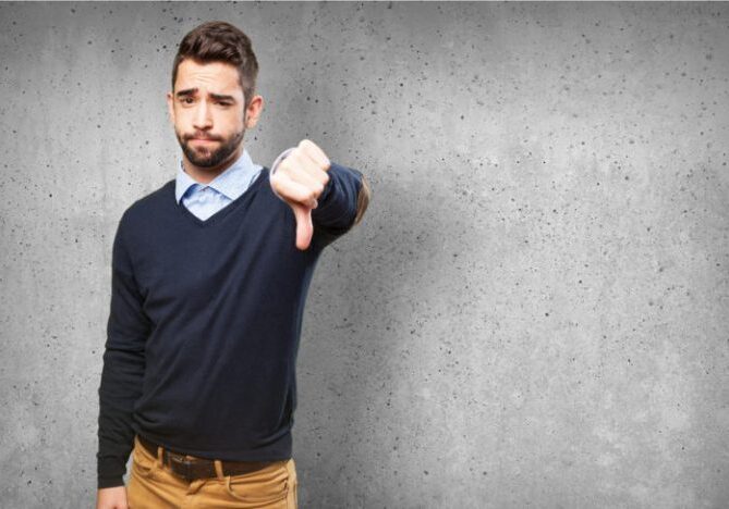 A man standing with thumbs down